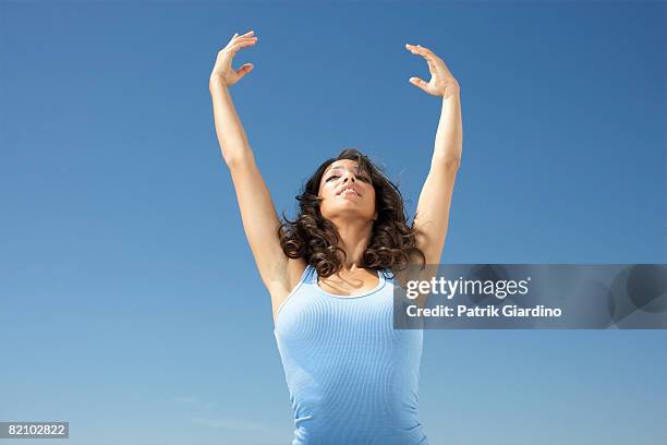 female stretching against blue sky - golvend haar stockfoto's en -beelden