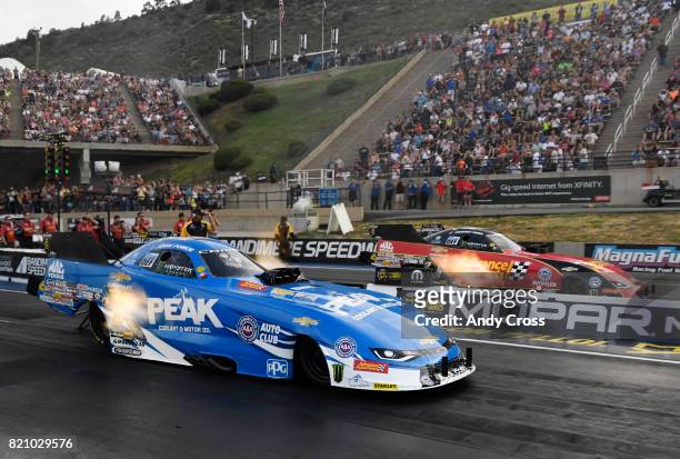 Funny car drivers John Force, left and his daughter Courtney Force race each other on the second day of the 38th annual NHRA Mopar Mile High...