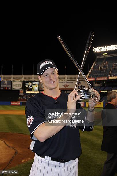 Justin Morneau of the Minnesota Twins stands with his trophy after the State Farm Home Run Derby at the Yankee Stadium in the Bronx, New York on July...