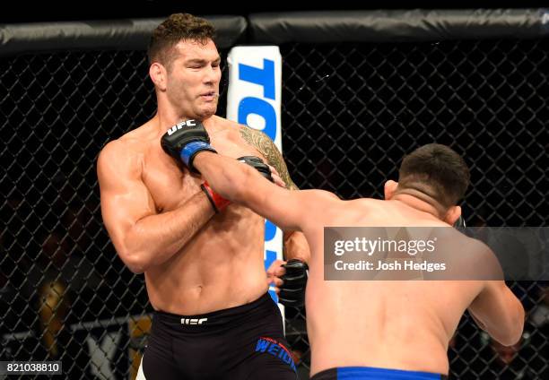 Kelvin Gastelum punches Chris Weidman in their middleweight bout during the UFC Fight Night event inside the Nassau Veterans Memorial Coliseum on...