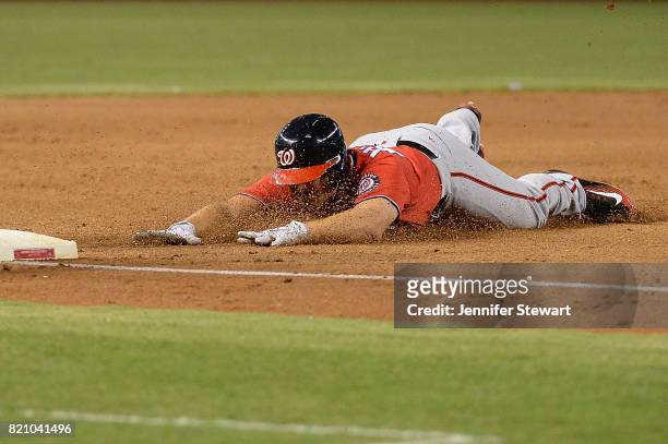 Chris Heisey of the Washington Nationals slides into a triple against the Arizona Diamondbacks in the sixth inning at Chase Field on July 22, 2017 in...