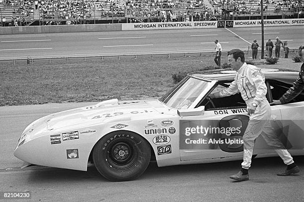 Don White pushes his Dodge Charger to the grid for the USAC stock car race as part of the unusual Twin Bill for stock and open wheel racers on July...