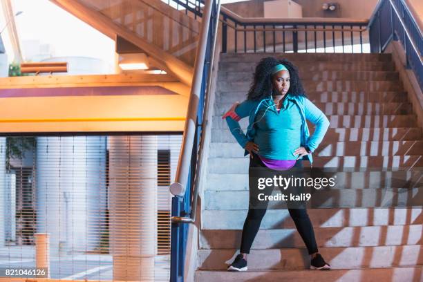 young black woman in workout clothing, hands on hips - fat hips stock pictures, royalty-free photos & images