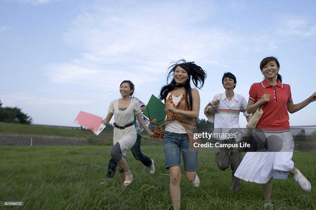 Five students running in an open field