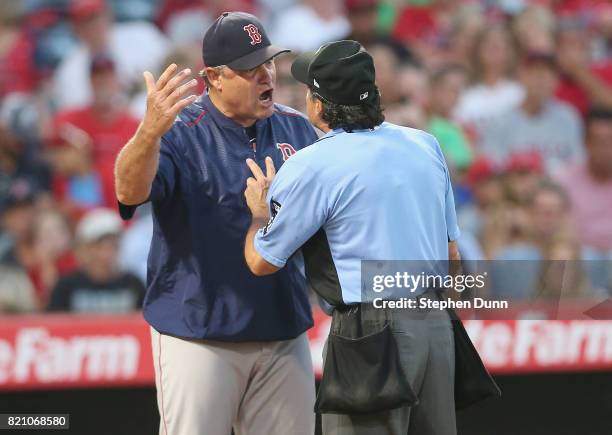 Manager John Farrell of the Boston Red Sox argues with home plate umpire Phil Cuzzi after Dustin Pedroia was called out on strikes to end the top of...