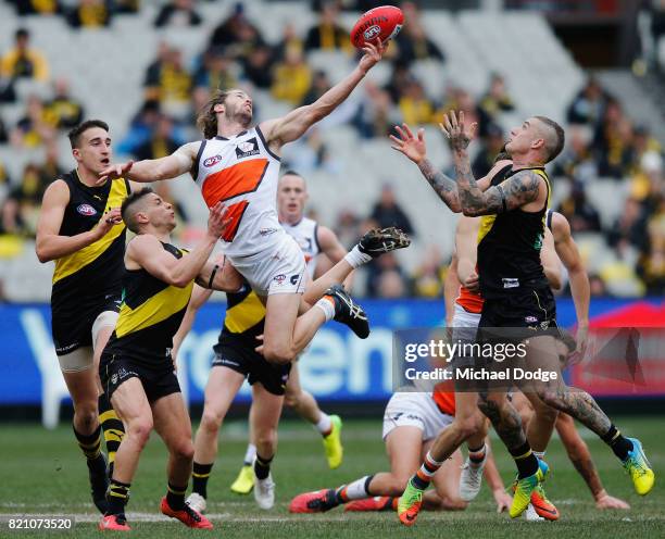 Callan Ward of the Giants gathers the ball from Dustin Martin of the Tigers during the round 18 AFL match between the Richmond Tigers and the Greater...