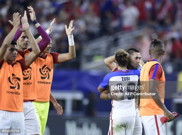 United States's forward Clint Dempsey is embraced by teammate Graham Zusi following their 2-0 victory in the CONCACAF Gold Cup semifinal match...