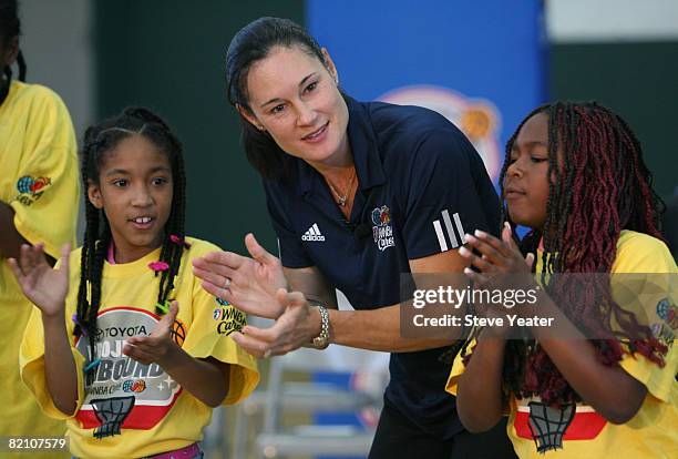 Legend Jennifer Azzi gets some help pumping up the crowd from Destiny Davis and Zharia Buchanan before the dedication of a new learning center at the...