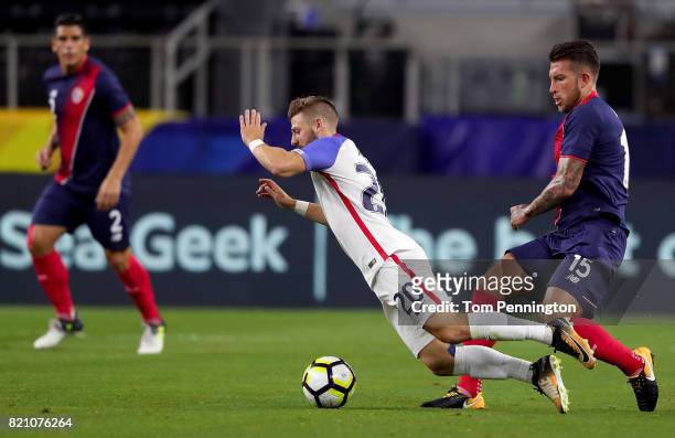 Paul Arriola of United States is tripped up by Francisco Calvo of Costa Rica during the 2017 CONCACAF Gold Cup Semifinal at AT&T Stadium on July 22,...