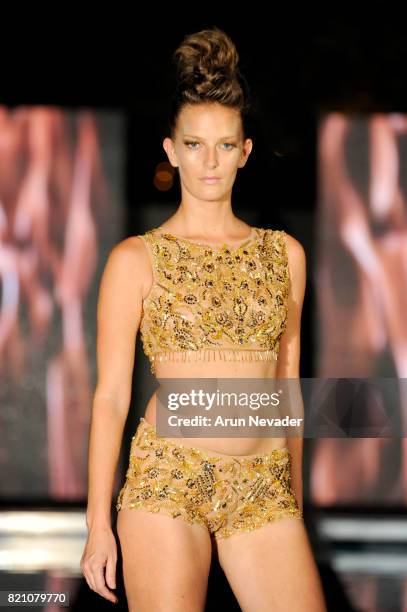 Model walks the runway at the Rocky Gathercole fashion show during the Art Hearts Fashion at Miami Swim Week at SLS Hyde Beach on July 22, 2017 in...