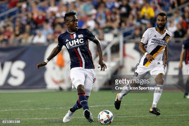 New England Revolution midfielder Gershon Koffie passes the ball watched by Los Angeles Galaxy defender Ashley Cole during a regular season MLS match...