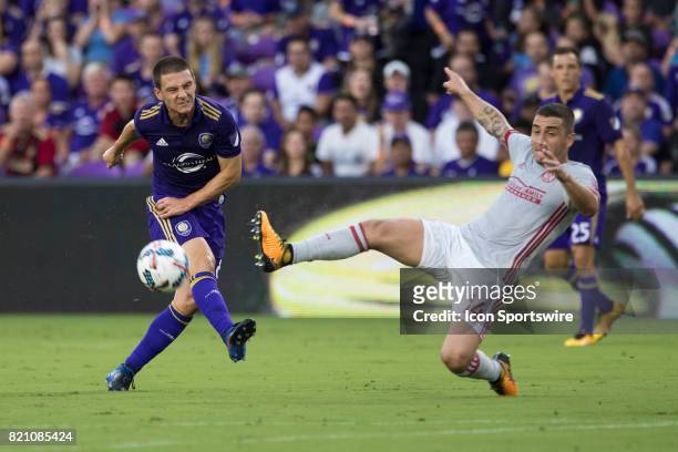 Orlando City SC forward Will Johnson kicks the ball and Atlanta United midfielder Carlos Carmona tries to block it during the MLS soccer match...