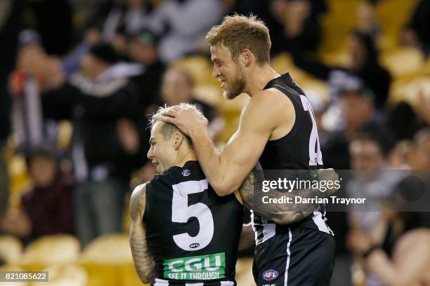 Jamie Elliott and Ben Reid of the Magpies celebrate a goal during the round 18 AFL match between the Collingwood Magpies and the West Coast Eagles at...