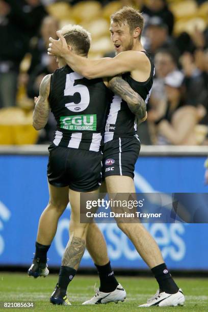 Jamie Elliott and Ben Reid of the Magpies celebrate a goal during the round 18 AFL match between the Collingwood Magpies and the West Coast Eagles at...