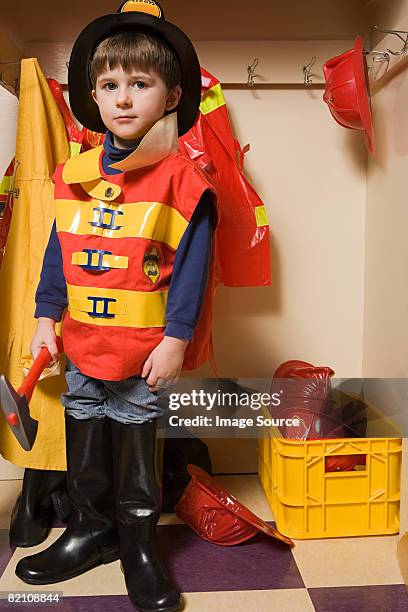 a boy pretending to be a firefighter - boy fireman costume stock pictures, royalty-free photos & images