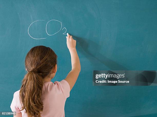 girl writing on a blackboard - child writing on chalkboard stock pictures, royalty-free photos & images