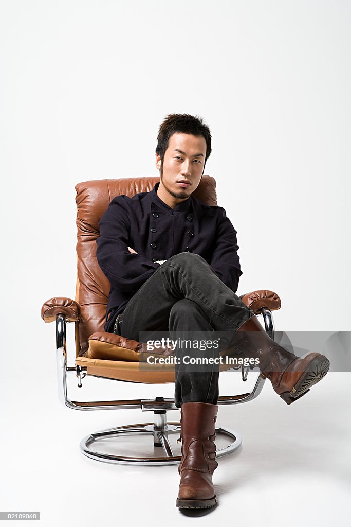 Japanese man sitting on a leather armchair