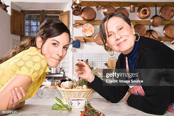 italian mother and daughter in kitchen - holding saucepan stock pictures, royalty-free photos & images