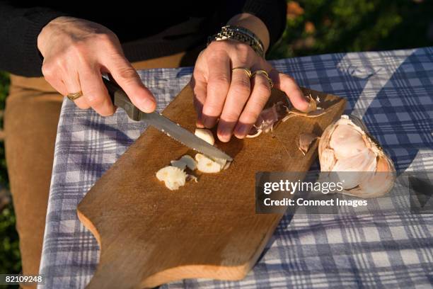 woman chopping garlic - chopping garlic stock pictures, royalty-free photos & images