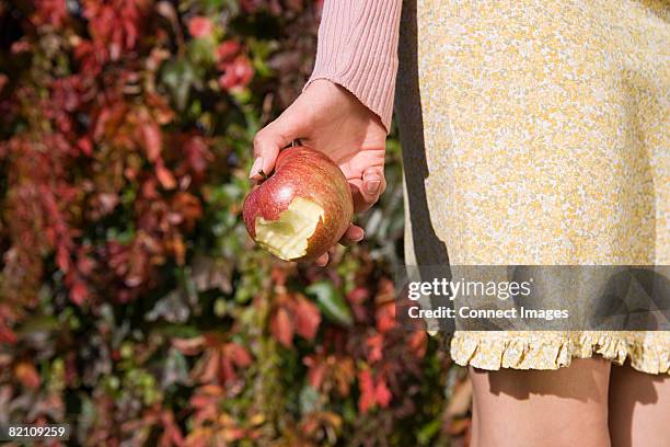woman holding a bitten apple - missing bite stock pictures, royalty-free photos & images