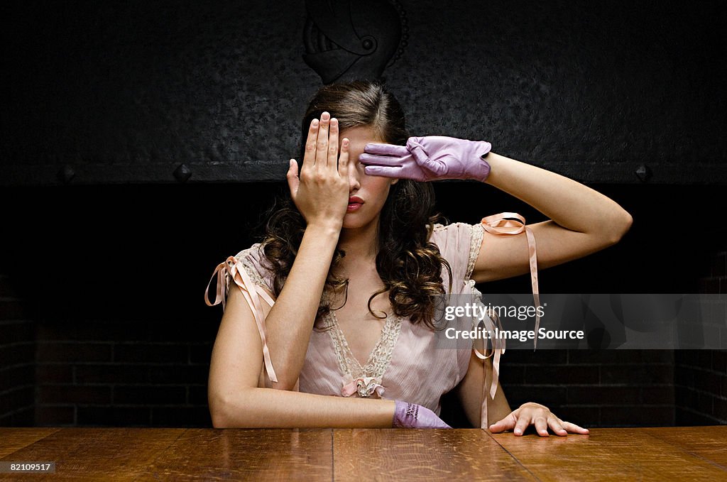 A woman with four arms covering her eyes