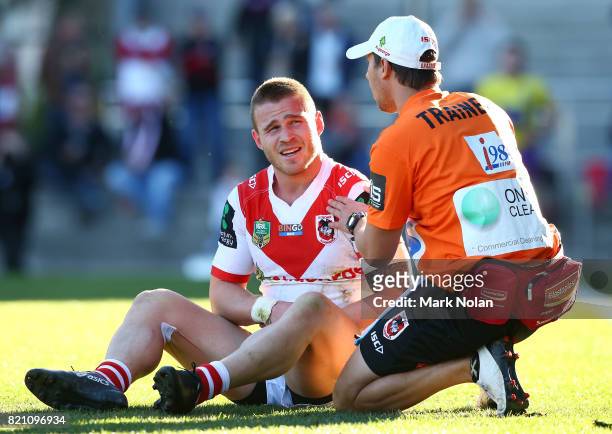 Euan Aitken of the Dragons receives attention for a shoulder injury after scoring during the round 20 NRL match between the St George Illawarra...