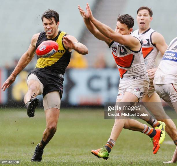 Alex Rance of the Tigers kicks the ball away from Josh Kelly of the Giants during the round 18 AFL match between the Richmond Tigers and the Greater...