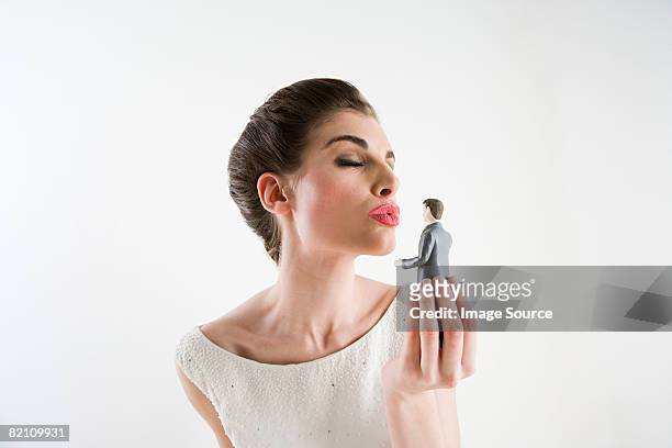 woman kissing bridegroom figurine - obsessive woman stock pictures, royalty-free photos & images