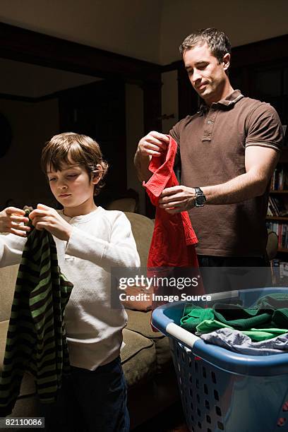 father and son folding laundry - man washing basket child stock pictures, royalty-free photos & images