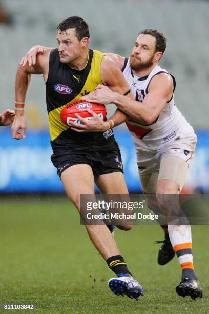 Toby Nankervis of the Tigers is tackled by Shane Mumford of the Giants during the round 18 AFL match between the Richmond Tigers and the Greater...