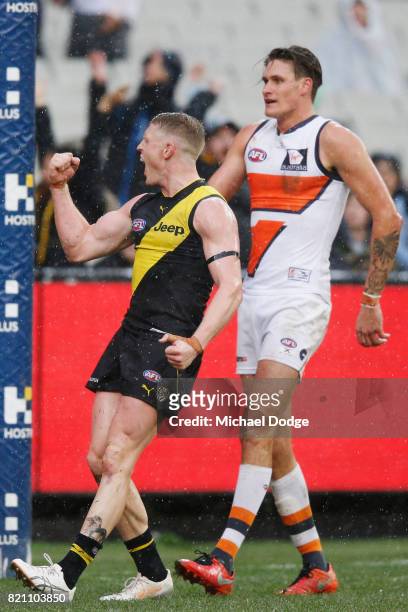 Josh Caddy of the Tigers celebrates a goal next to Rory Lobb of the Giants during the round 18 AFL match between the Richmond Tigers and the Greater...