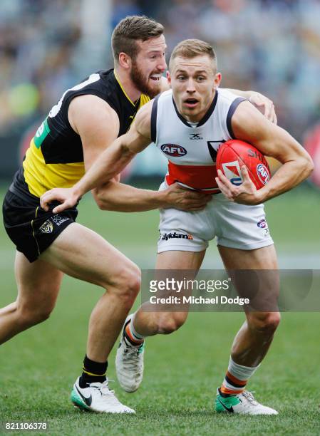 Kane Lambert of the Tigers tackles Devon Smith of the Giants during the round 18 AFL match between the Richmond Tigers and the Greater Western Sydney...