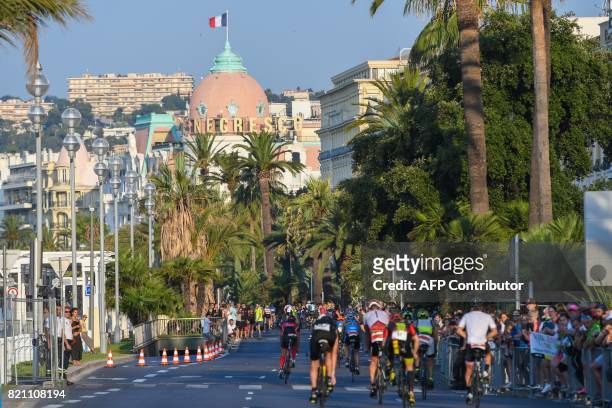 Competitors take the start of the bicycle race after completing the swimming race of the 13th Ironman thriathlon in Nice on July 23 with the Negresco...