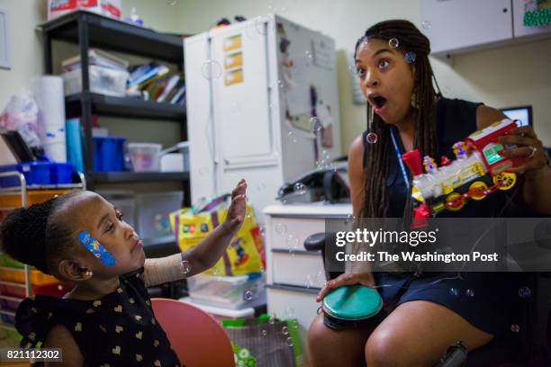 Speech therapist Sherelle Smith works with her student Kamille Davis at St. Coletta school on July 19, 2017 in Washington, D.C.