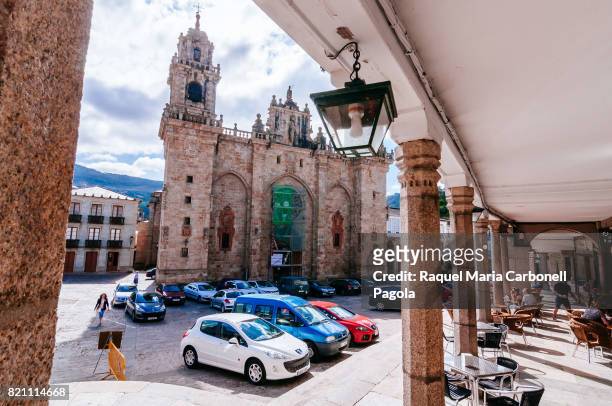 People sitting at a cafe bar terrace in front of the Cathedral of Mondoñedo.