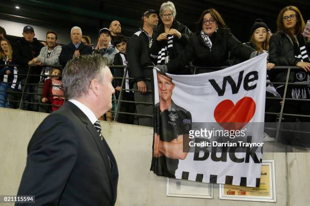 Fans show Collingwood President Eddie McGuire their support of senior coach Nathan Buckley of the Magpies during the round 18 AFL match between the...