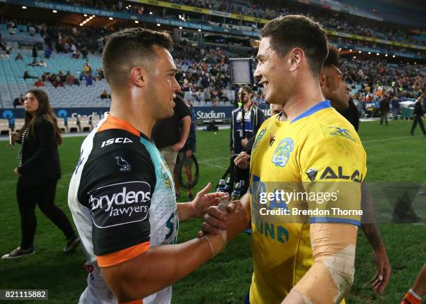 Mitchell Moses of the Eels shakes hands with Luke Brooks of the Tigers following the round 20 NRL match between the Wests Tigers and the Parramatta...