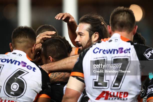 Malakai Watene-Zelezniak of the Tigers celebrates with team mates after scoring a try during the round 20 NRL match between the Wests Tigers and the...