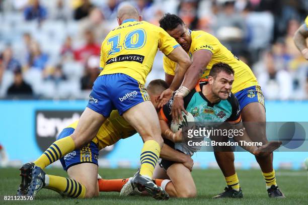 Tim Grant of the Tigers is tackled by the Eels defence during the round 20 NRL match between the Wests Tigers and the Parramatta Eels at ANZ Stadium...