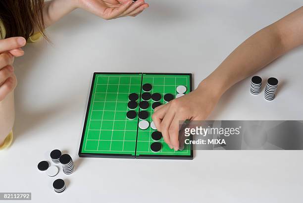 two young women playing othello game - othello stock pictures, royalty-free photos & images