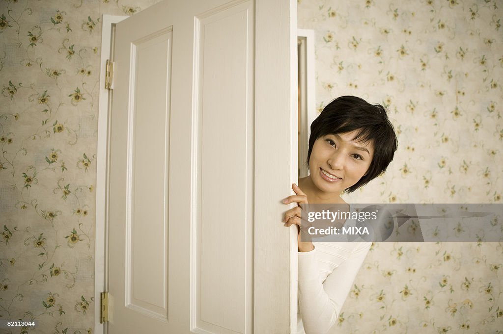 Young woman opening door