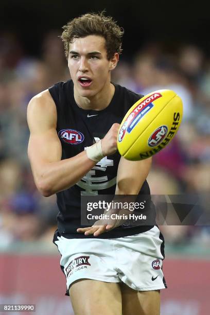 Tom Williamson of the Blues handballs during the round 18 AFL match between the Brisbane Lions and the Carlton Blues at The Gabba on July 23, 2017 in...