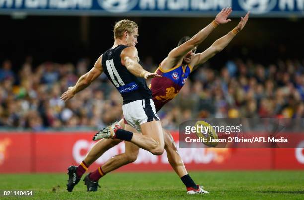 Sam Kerridge of the blues gets a kick away past Sam Mayes during the round 18 AFL match between the Brisbane Lions and the Carlton Blues at The Gabba...