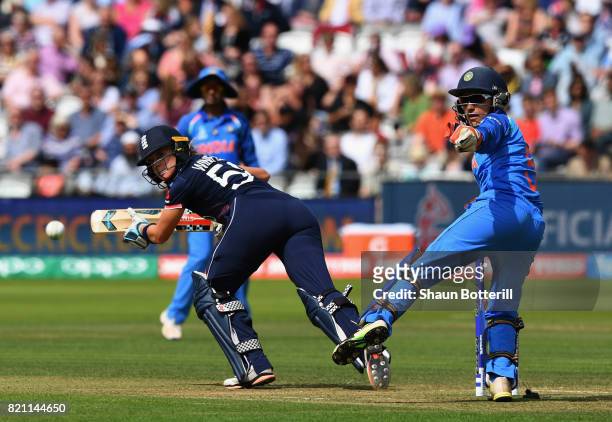 Lauren Winfield of England plays a shot as wicket keeper Sushma Verma of India looks onduring the ICC Women's World Cup 2017 Final between England...