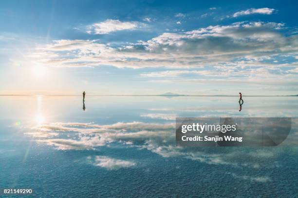 sunset glow reflection at salar de uyuni - uyuni stock-fotos und bilder