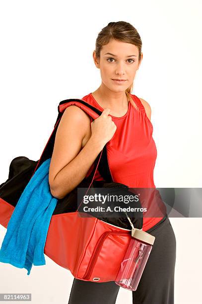 portrait of a young woman carrying a gym bag - carrying sports bag foto e immagini stock