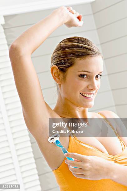 reflection of a young woman shaving her armpit hair - armpit hair woman stock pictures, royalty-free photos & images