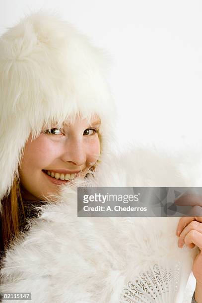 portrait of a young woman holding a feather fan and smiling - feather fan stock pictures, royalty-free photos & images