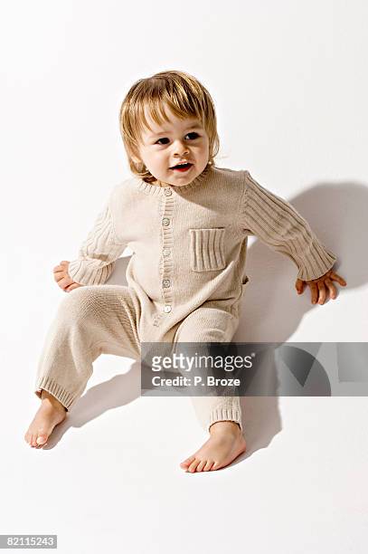 high angle view of a baby boy sitting on the floor and smiling - sitta på golv bildbanksfoton och bilder