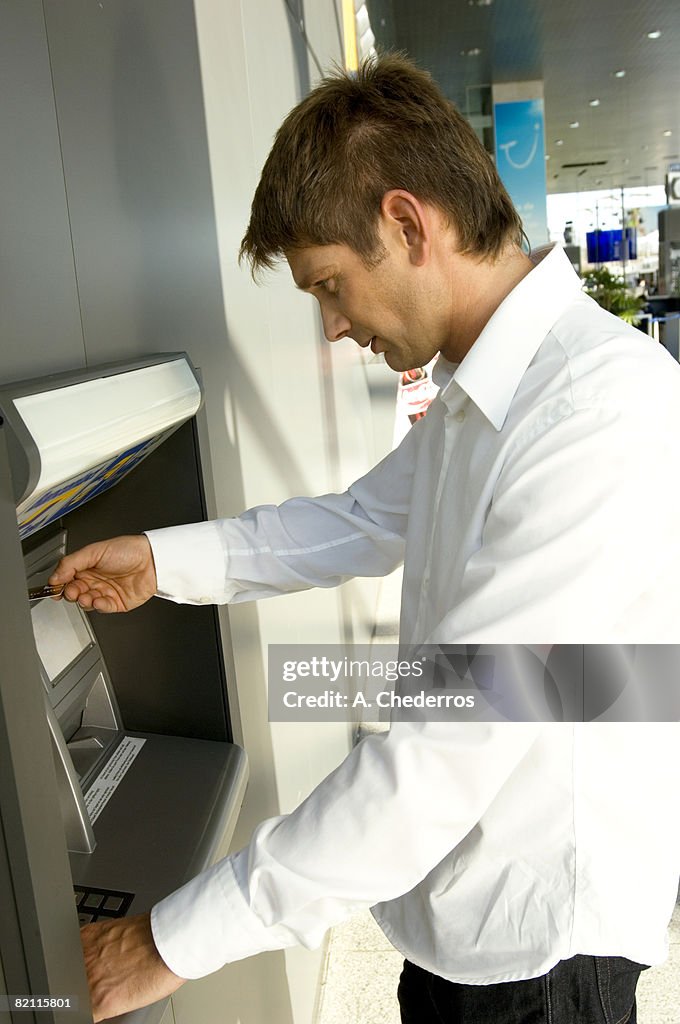 Side profile of a businessman using an ATM